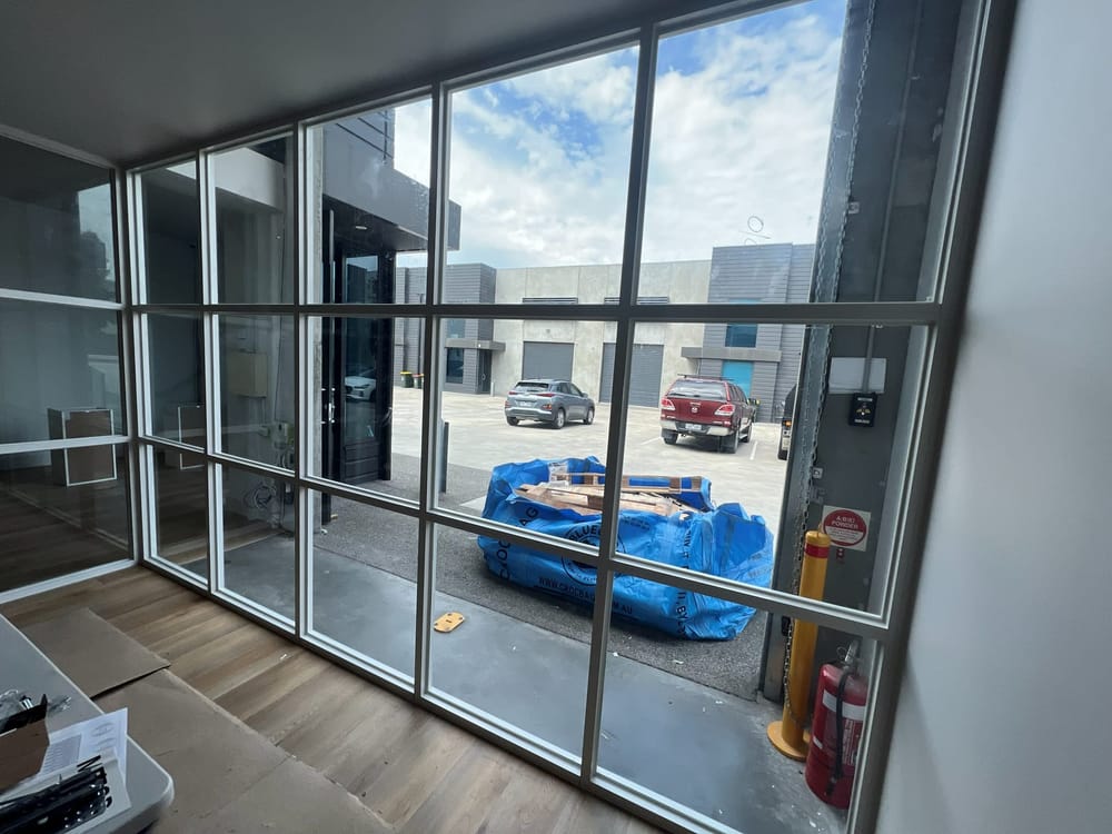 The same glazed partition from inside the office, looking out to the car park