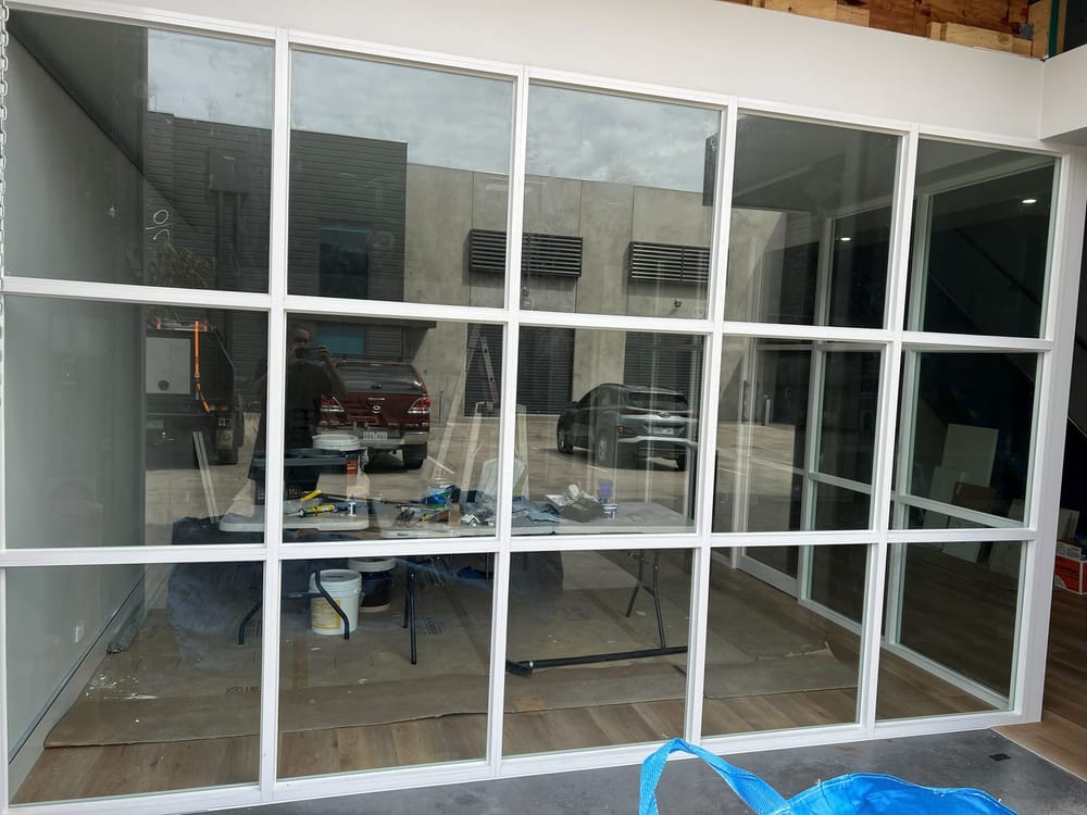 Large commercial glazed partition with white framing installed in an office