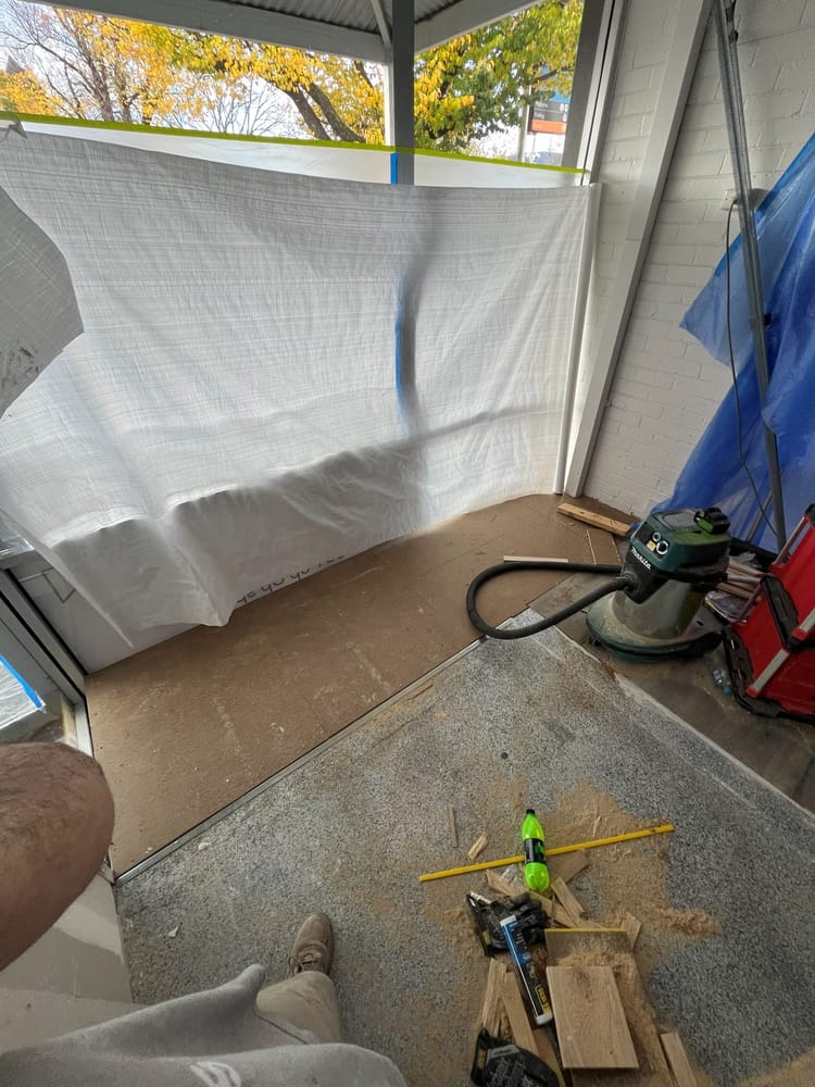 Plastic dust protection sheeting hung across a work area with a vacuum on the floor