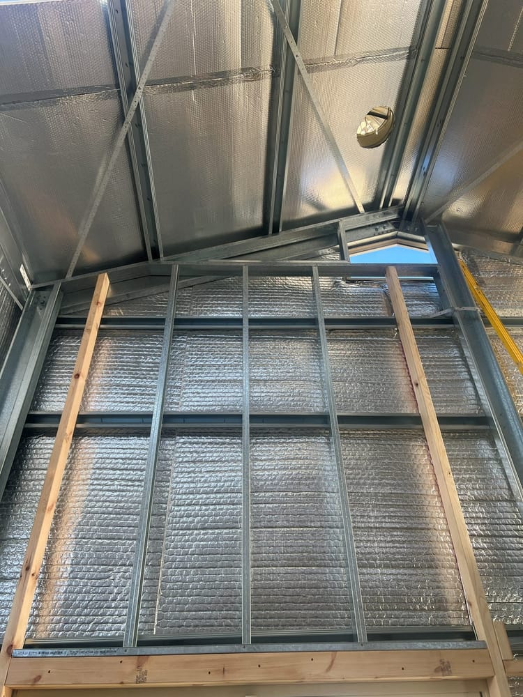 Steel and timber framing installed inside a shed, looking up towards the roof sheeting