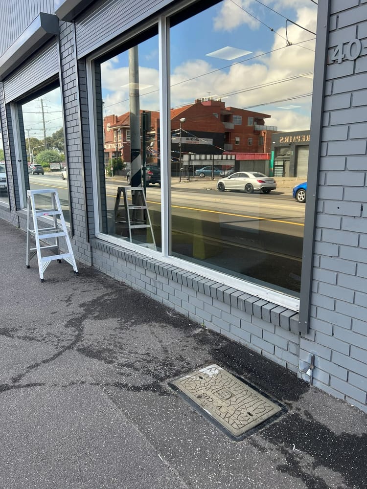 Completed shopfront window replacement in a brick wall, viewed from the street